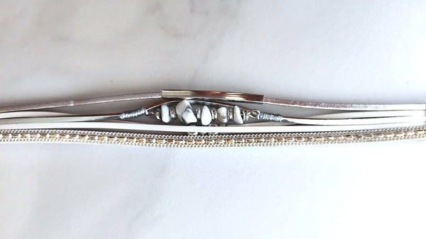 Pulsera multicapa en blanco pálido con piedras semipreciosas blancas y detalles de cuentas.