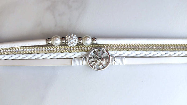 Pulsera blanca de múltiples rayas con dije de árbol de la vida y cristales brillantes.